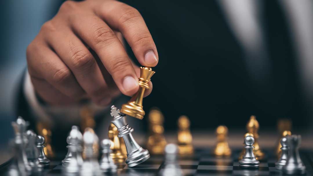 hand of businessman moving chess figure in competition